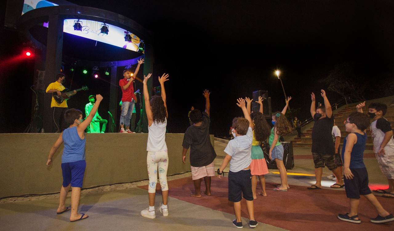 crianças brincando na frente de um palco no anfiteatro da Beira-Mar
